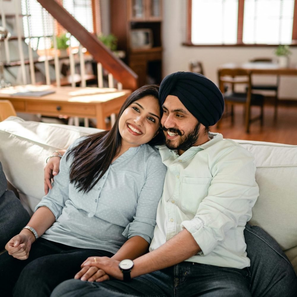 Happy couple enjoying a relaxing moment together on a sofa in a modern living room.
